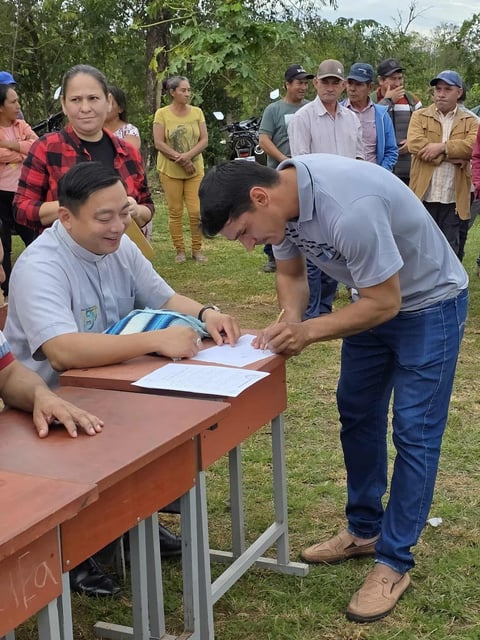 Father Viet Hong SVD signs community agreement to build water tanks in Paraguay community.